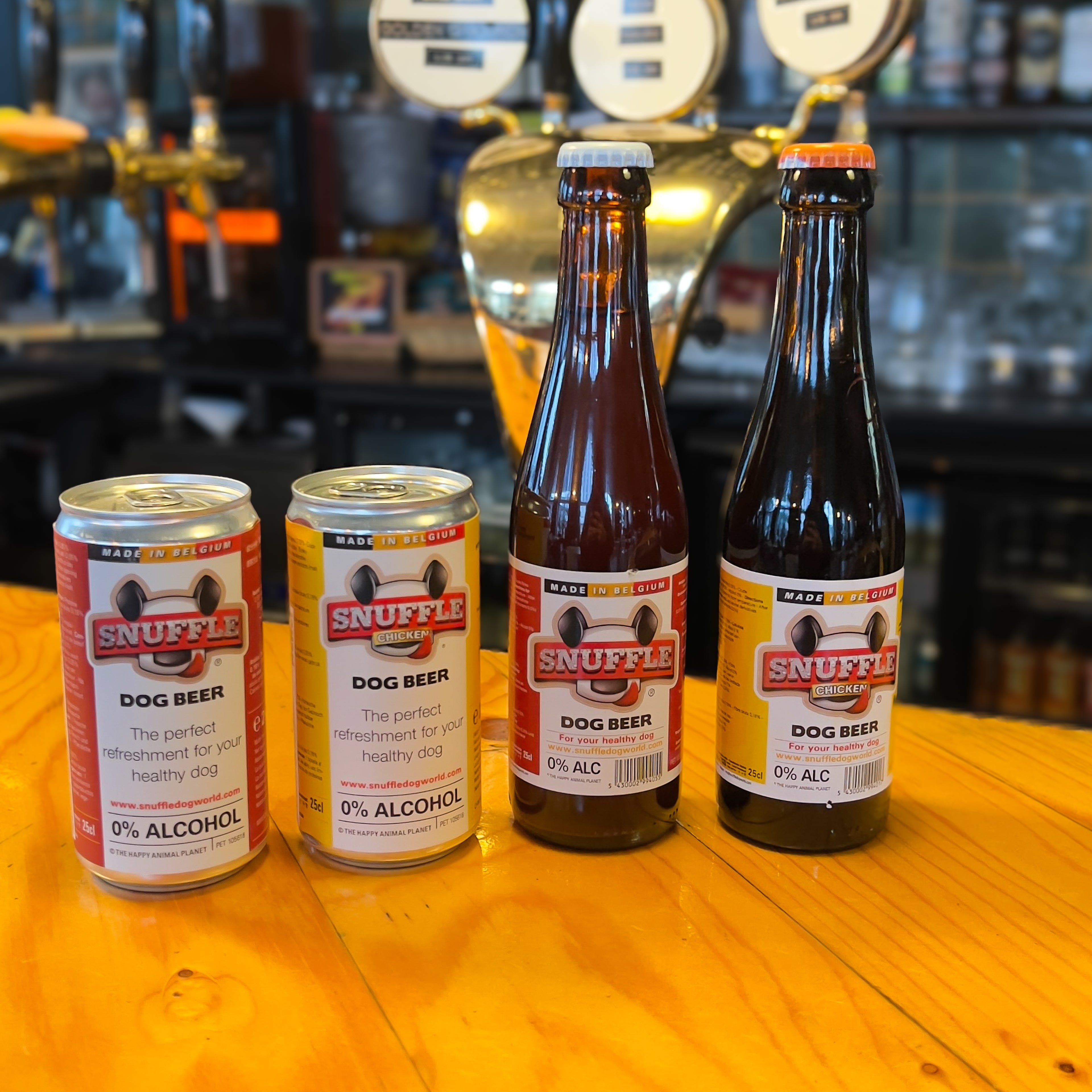 Four bottles of Snuffle dog beer on a bar counter with blurred bar background